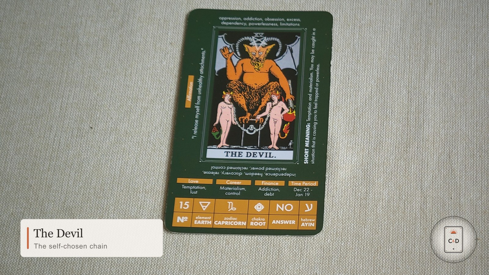 The Devil tarot card meaning, the card face-up on linen in warm natural light