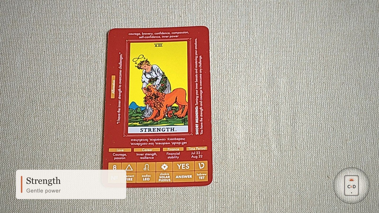 Strength tarot card meaning, the card face-up on linen in warm natural light