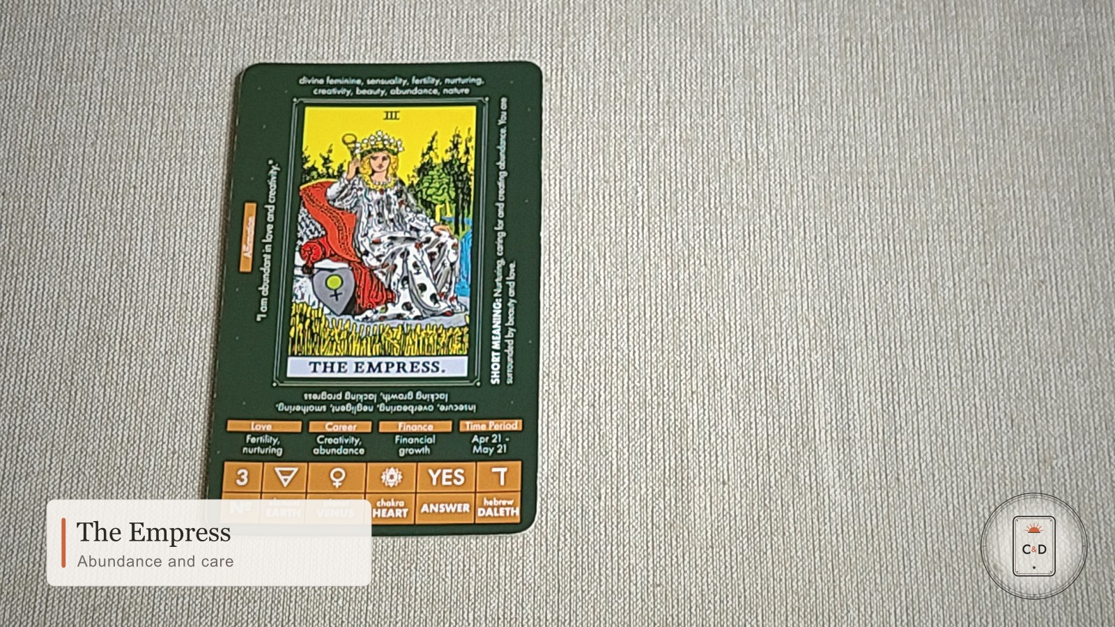 The Empress tarot card meaning, the card face-up on linen in warm natural light
