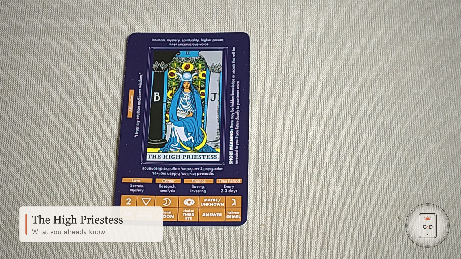 The High Priestess tarot card meaning, the card face-up on linen in soft natural light